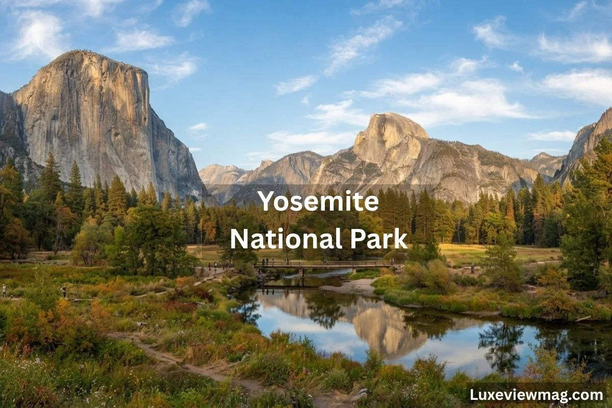 A scenic view of Yosemite National Park shows mountains, green trees, and a reflective river under a bright blue sky with scattered clouds.