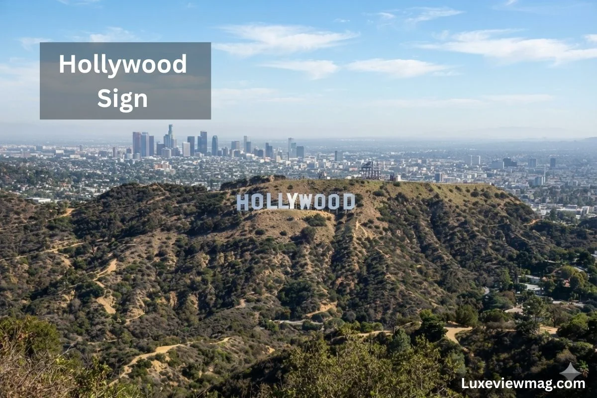 The Hollywood Sign, a famous landmark, is prominently displayed on a hillside in Los Angeles against a clear sky.