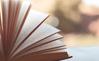 An open book resting on a table, featuring a softly blurred background, associated with MyDearQuotes.com Blog.