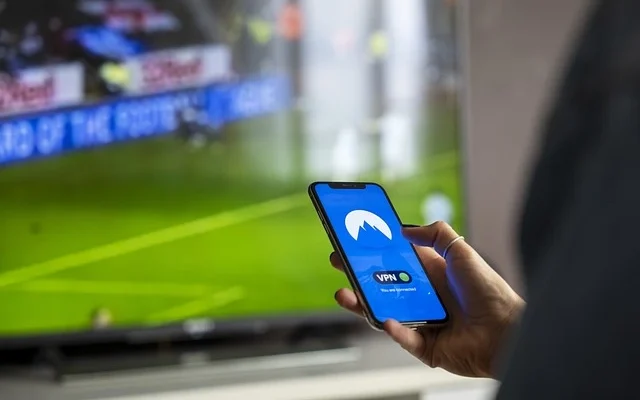 An individual watching soccer on their phone, with the French Stream.moe interface visible on the device's screen.