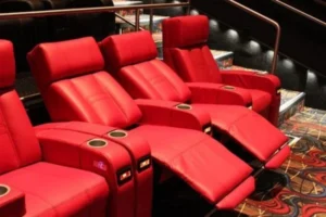 A row of red leather recliners in the CMX Cinemas Tyrone Luxury 10 movie theater, arranged for optimal viewing comfort.