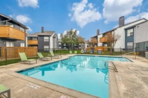 A serene pool at Emmitt Luxury Apartments, surrounded by lush greenery in the park area of the apartment complex.