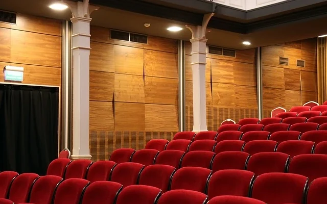 A spacious auditorium featuring red seating and a black curtain, located in Century Square Luxury Cinemas.