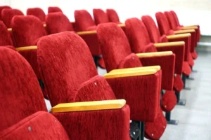 Interior view of Mystic Luxury Cinemas showcasing rows of red chairs in the auditorium, prepared for an enjoyable film screening.