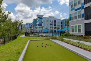 A well-maintained lawn featuring a swimming pool and a billiards table at Ciel Luxury Apartments.