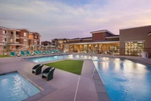 The pool at Zaterra Luxury Apartments illuminated by a stunning sunset, creating a serene and picturesque atmosphere.