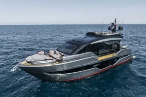 A Cranchi Sessantasette 67 Corsa motor yacht glides gracefully on the water under a clear blue sky.