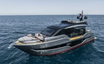 A Cranchi Sessantasette 67 Corsa motor yacht glides gracefully on the water under a clear blue sky.