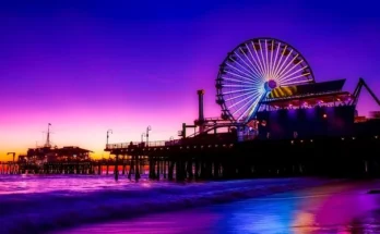 Santa Monica beach Pier with colorful rides and beachgoers, overlooking Santa Monica Beach in California.
