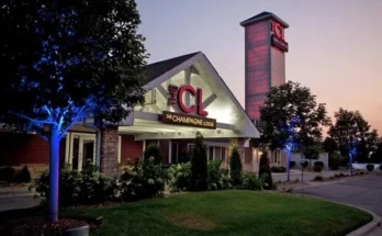 The Champagne Lodge & Luxury Suites exterior at dusk, illuminated by soft blue lights.