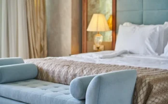 A stylish hotel room at hotel ivy a luxury collection hotel minneapolis​, featuring a comfortable bed, a table, and a vase for added elegance.