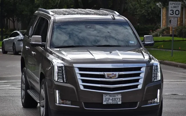 The front end of a parked 2024 cadillac lyriq 600e4 awd luxury​ suv on a city street, highlighting its modern features.