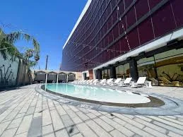 The hotel pool at Ahern Luxury Boutique Hotel, surrounded by lush palm trees, offers a serene relaxation space.