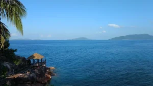 A scenic view of the ocean from a resort overlooking Las Tunas Beach, with clear blue waters and a sunny sky.