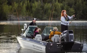 Several individuals on a boat engaged in fishing, surrounded by water and clear skies, showcasing a recreational veneajelu outing.