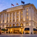 Palace Hotel San Francisco exterior at dusk, featuring its grand historic facade, illuminated entrance, and a classic San Francisco cable car in the foreground.